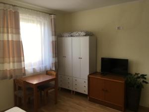 a room with a cabinet and a table and a television at Lindenhof Ybbs in Ybbs an der Donau