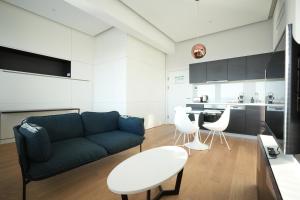 a living room with a blue couch and white chairs at Exclusive 1-bedroom apartment in Vienna