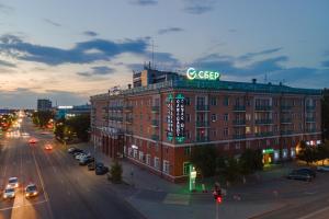 Un gran edificio de ladrillo rojo con un cartel. en Гостиница Караганда, en Karagandá