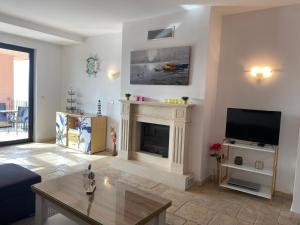 a living room with a fireplace and a tv at 59 Kaliakria Seaview Luxury Apartment in Topola