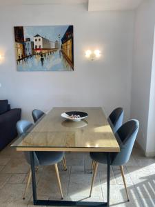 einen Esstisch mit Stühlen und ein Gemälde an der Wand in der Unterkunft 59 Kaliakria Seaview Luxury Apartment in Topola