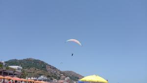 a kite flying in the sky over a beach at La terrazza sul mare in Letojanni