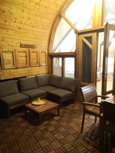 ein Wohnzimmer mit einem Sofa und einem Tisch in der Unterkunft Gesztenye Nyaralópark in Balatonudvari