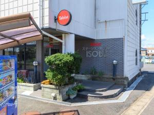 un magasin avec un panneau sur le côté d'un bâtiment dans l'établissement Tabist Station Hotel Isobe Ise-Shima, à Shima