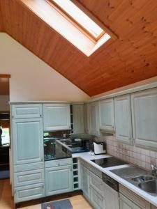 a kitchen with white cabinets and a skylight at Soubey (Clairbief) in Soubey
