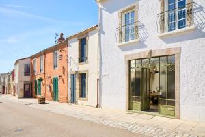 a row of buildings with green doors on a street at Gîte Des Caves Secrètes in Tiffauges