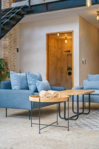 ein Wohnzimmer mit 2 Tischen und blauen Sofas in der Unterkunft Villa Upeksha - Huge 1-bedroom Villa with pool in Pererenan in Munggu