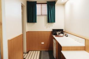 baño con lavabo y ventana en Echuca Nirebo Motel, en Echuca