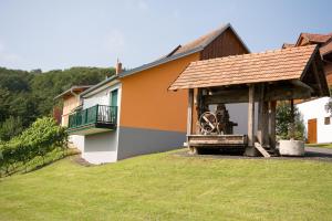 ein Haus mit einem Gebäude mit einem Rad darin in der Unterkunft Gästehaus - Camping- Weinhof Radl in Klöch