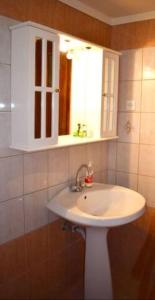 ein Badezimmer mit einem weißen Waschbecken und einem Spiegel in der Unterkunft Marble Cool 2-bedroom Down Town Yard House in Kissamos