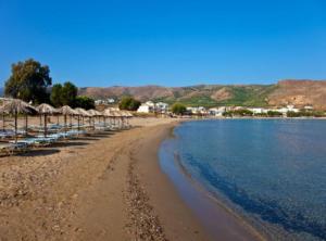 ein Strand mit Stühlen und Sonnenschirmen und das Meer in der Unterkunft Marble Cool 2-bedroom Down Town Yard House in Kissamos