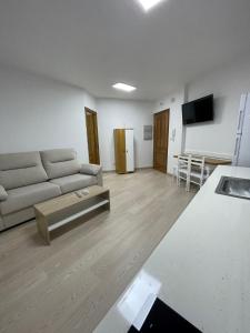 ein Wohnzimmer mit einem Sofa und einem Tisch in der Unterkunft APARTAMENTOS TURISTICOS ARANZAZU in Losar de la Vera