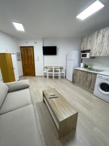 ein Wohnzimmer mit einem Sofa und einem Tisch darin in der Unterkunft APARTAMENTOS TURISTICOS ARANZAZU in Losar de la Vera