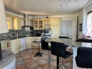 a kitchen with white cabinets and a marble counter top at O rivage du Mont 10/12 pers in Huisnes-sur-Mer