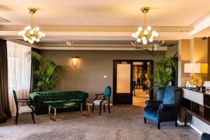 a lobby with a green couch and chairs at Aria by Brilliant in Zalău
