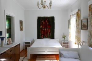 Un dormitorio blanco con una cama y un sofá. en Ylatupa, en Kesälahti