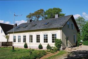a large white house with a black roof at Ferienwohnungen Gut Oestergaard in Steinberg