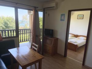 a room with a bed and a table and a balcony at Complex Terazini in Byala