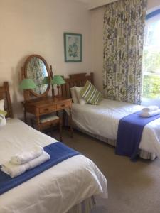 a hotel room with two beds and a mirror at 17 MONTEGO BAY CARIBBEAN ESTATES in Port Edward
