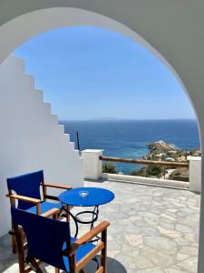 patio ze stołem i krzesłami oraz oceanem w obiekcie Charakas Horizon w mieście Gavrion