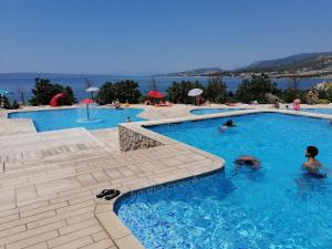 a group of people swimming in a swimming pool at Mobile Home Livanda in Klenovica