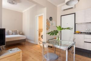 een woonkamer met een glazen tafel en een slaapkamer bij Italian Experience-Lungarno Suite Apartment in Florence