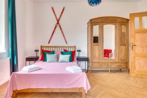 - une chambre avec un lit rose et un miroir dans l'établissement QQłka Apartament z widokiem, à Szklarska Poręba