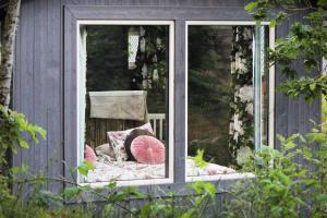 ein Fenster eines Hauses mit einem Stuhl darin in der Unterkunft Toric Farmlodge in Brastad