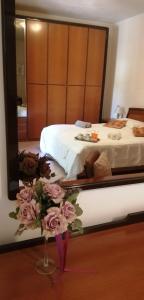 Un dormitorio con una cama con un jarrón de flores en Camere Rosy en Palazzo
