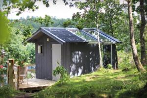 a shed with a solar roof and a wooden deck at Toric Farmlodge in Brastad