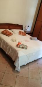 Una cama blanca con una bandeja de comida. en Camere Rosy en Palazzo