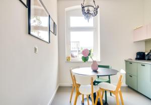 - une cuisine et une salle à manger avec une table et des chaises dans l'établissement QQłka Apartament z widokiem, à Szklarska Poręba