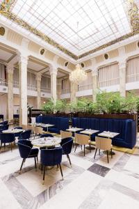 a dining room with tables and chairs in a building at Grandhotel Pupp in Karlovy Vary