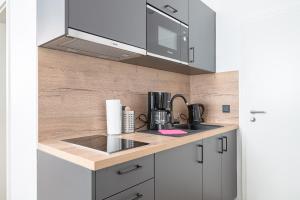 uma cozinha com um lavatório e um micro-ondas em JOHOUSE Apartment 08 em Warnemünde