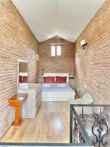 1 dormitorio con cama y pared de ladrillo en sweet home in old tbilisi en Tiflis
