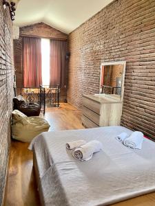 1 dormitorio con 1 cama grande y pared de ladrillo en sweet home in old tbilisi en Tiflis