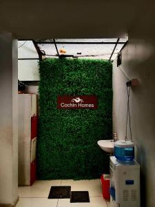 a green wall in a room with a toilet at COCHIN HOMES in Ernakulam