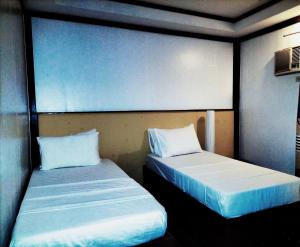 dos camas sentadas una al lado de la otra en una habitación en Orange Pearl Beach Resort, en El Nido
