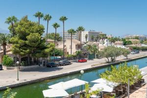 una ciudad con un río con sombrillas y una calle en Apartment Scandi - Alcúdia, en Alcudia