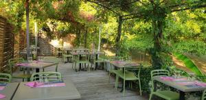 a patio with tables and chairs under a pergola at Hôtel La Barguelonne in Montcuq