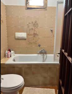 een badkamer met een toilet en een bad bij Cheerful Room, Sharing kitchen in a Cosy Family Art House, Ideal for one person or couple in Sanremo