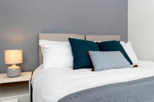 a bedroom with a bed with blue and white pillows at Amazing House with Central Location in Darlington