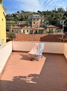 een stoel bovenop een balkon bij Cheerful Room, Sharing kitchen in a Cosy Family Art House, Ideal for one person or couple in Sanremo