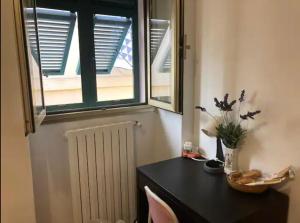 een kamer met een zwarte tafel en een raam bij Cheerful Room, Sharing kitchen in a Cosy Family Art House, Ideal for one person or couple in Sanremo