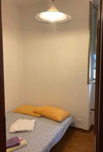 een kamer met een bed met een kussen erop bij Cheerful Room, Sharing kitchen in a Cosy Family Art House, Ideal for one person or couple in Sanremo