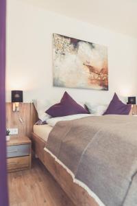een slaapkamer met een bed en een schilderij aan de muur bij Apartments z‘Haus in St. Gilgen