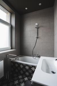 a bathroom with a bath tub and a sink at La Villa Delsa in Namur
