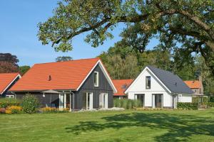 una casa con techo naranja y una casa blanca en Villapark Ehzerburg, en Almen