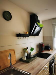a kitchen with a sink and a clock on the wall at Villa Carmen in Halbemond +13 photos
