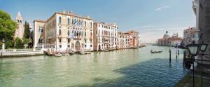 a canal with buildings and a boat in the water at Hotel Galleria in Venice